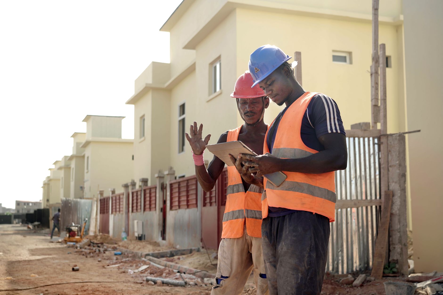 Two workers on a residential site reviewing drawings together.