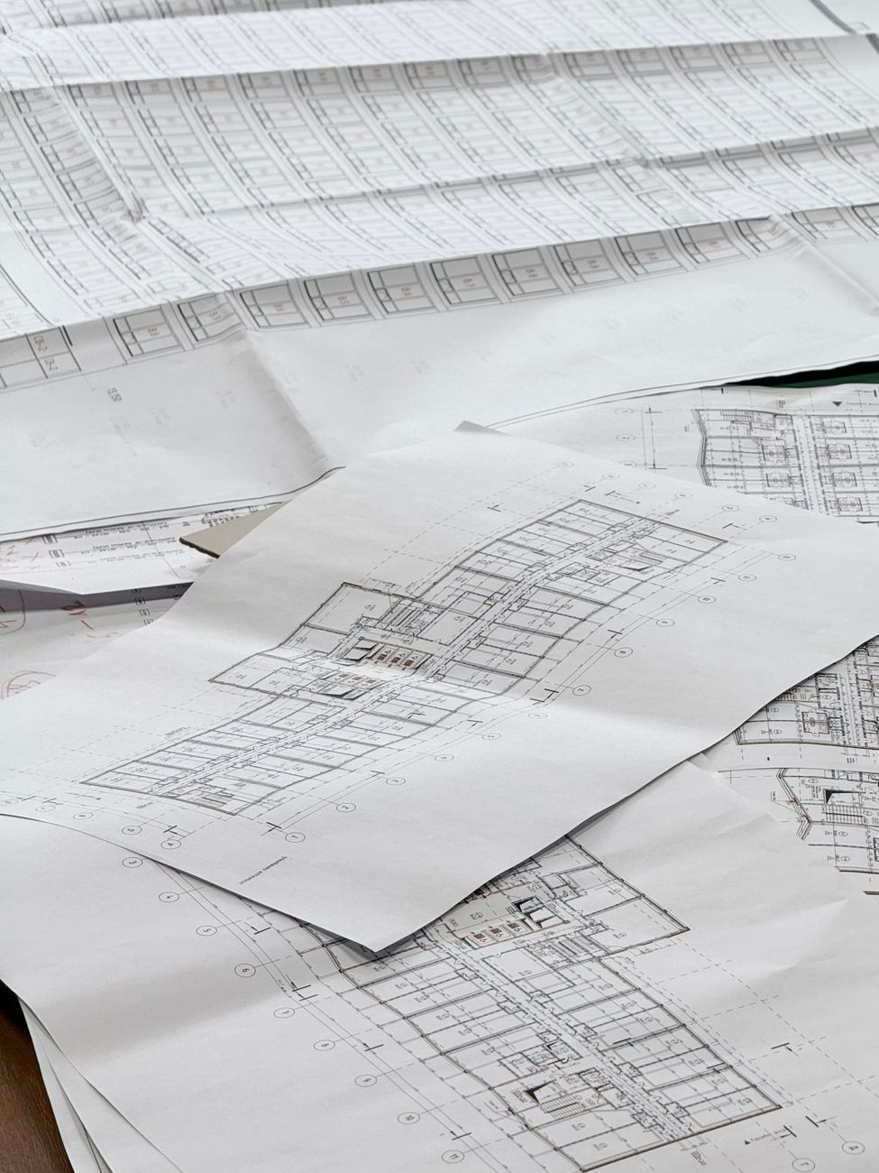 Detailed building drawings spread across a desk.